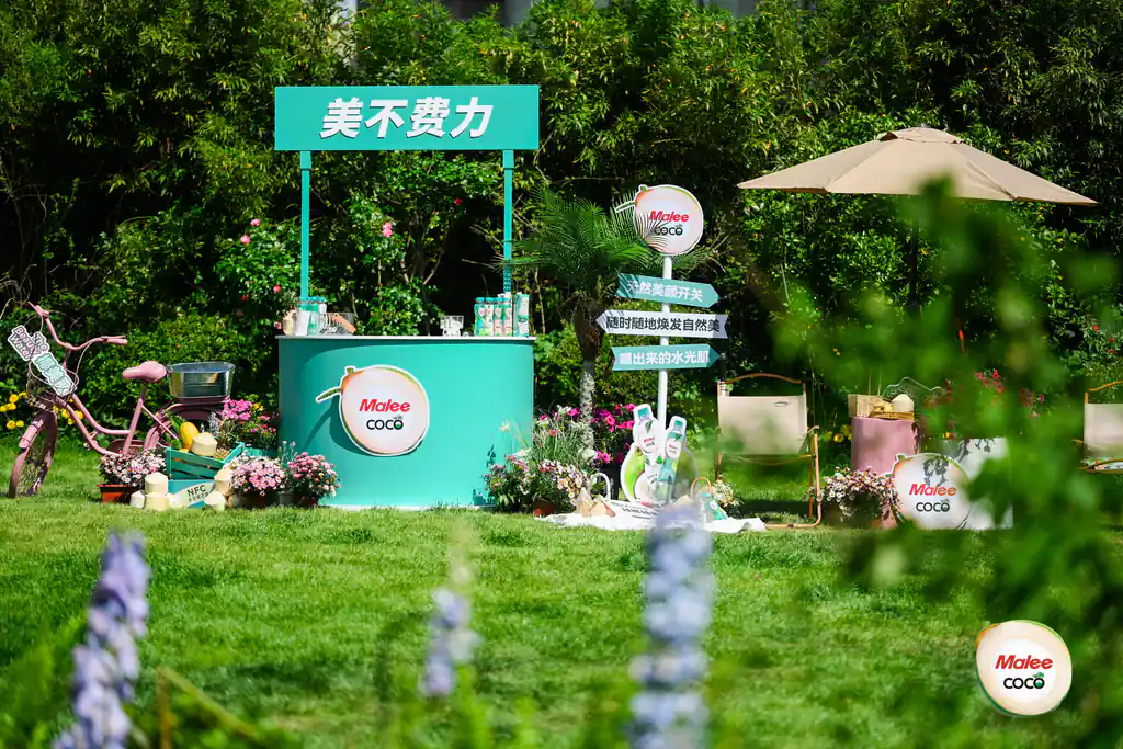 大草坪上的品牌快闪布置:展台、遮阳伞与花境